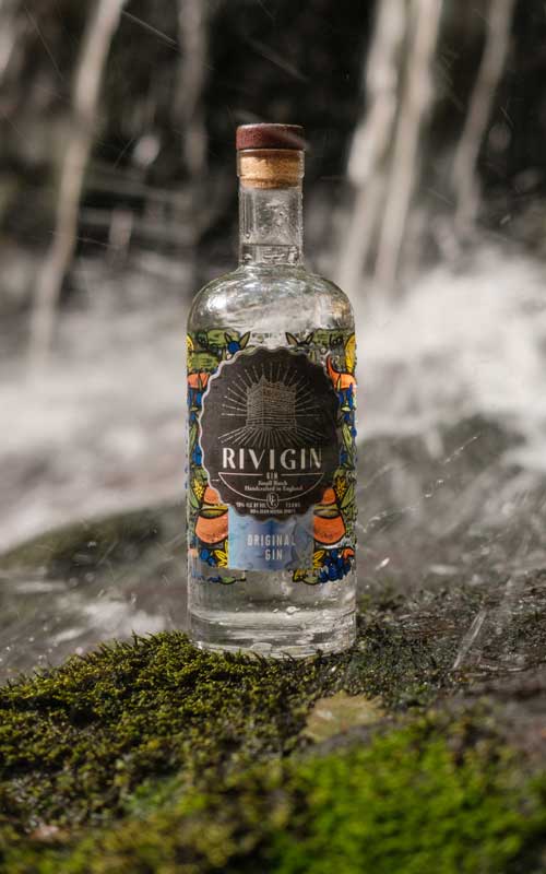 Rivi gin bottle in front of a waterfall